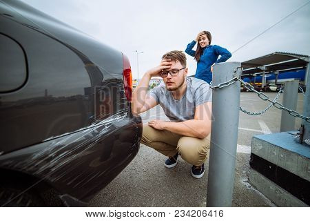 Man With Sad Look On Scratched Car. Woman With Sorry Look Near Dent Auto. Insurance Case.
