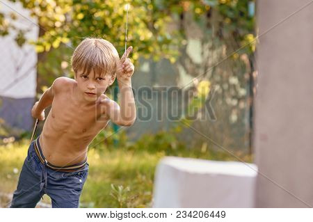 Concentrated Sporty Young Boy Training With Throwing Knife