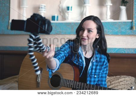 Musician With Acoustic Guitar On The Bed Records Herself On Dslr Camera Keeping It In Front Of Him O