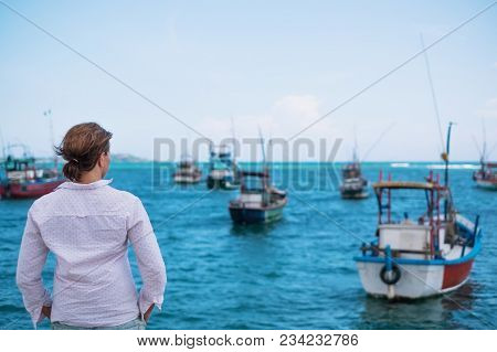 Caucasian Woman Standing On The Beach Of Midigama And Looking On Ocean And Traditional Colourful Loc