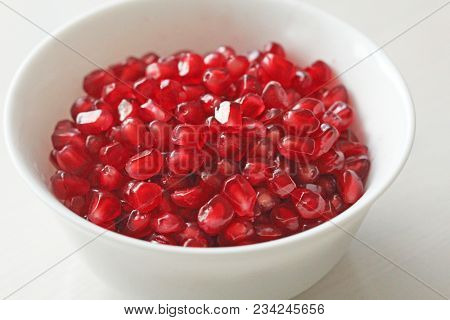 Grains Of Red Ripe Pomegranate Lie In A White Bowl. Big Ripe Red Granets Or Garnets. Fruits Of Red R