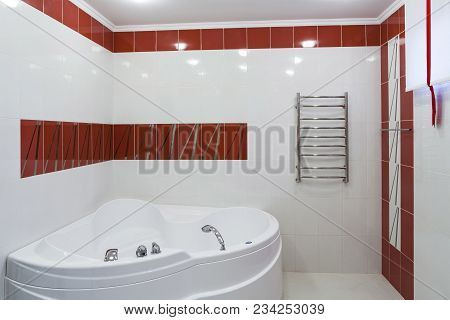Interior Of A Modern Bathroom. Corner Acrylic Bath.
