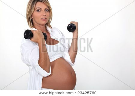 Těhotná žena zvedání handweights