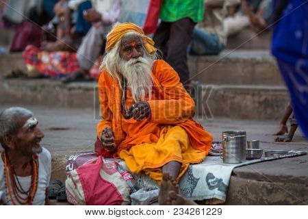 VARANASI, INDIA - MAR 29, 2018: Sadhu or Baba (holy man) on the ghats of Ganges river. Normally a sadhu is a monk, renounced, renounced material enjoyment. In India from 4 to 5 million sadhu.