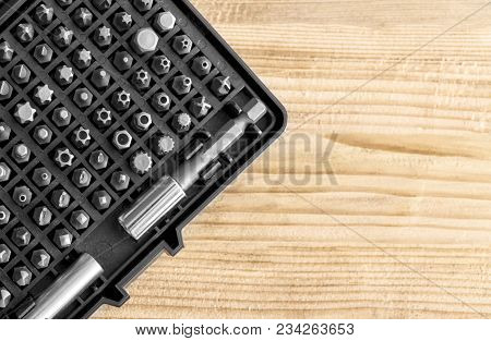 A Set Of Bits For A Screwdriver Of Different Shapes In The Box On A Wooden Surface Close Up. Tool Fo