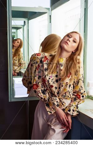 Girl With Long Hair, Long Sleeve Shirt With Floral Print And Wide White Pants. A Wistful Romantic Lo