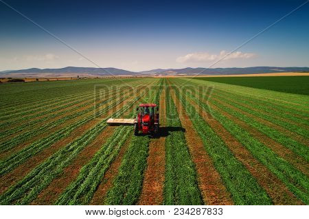 Tractor Mowing Green Field, Aerial Drone View.