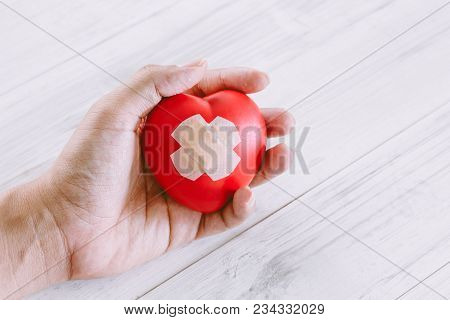 Hand Holdind Red Heart On Wooden Background