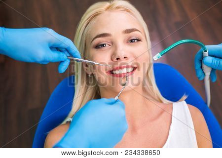 Woman Patient Sitting At Reception With Dentist And Hands With Tools.