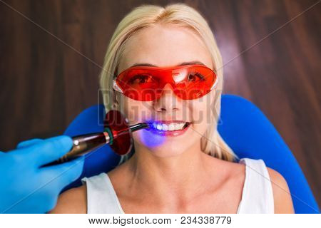Woman Patient Sitting At Reception With Dentist And Hands With Tools.