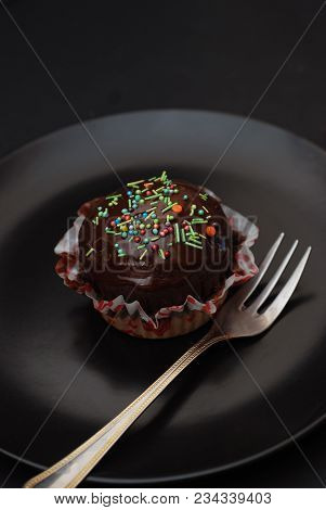 Homebaked Chocolate Muffins For Easter With Colored Conffeti. Dark Background. Sweet Dessert