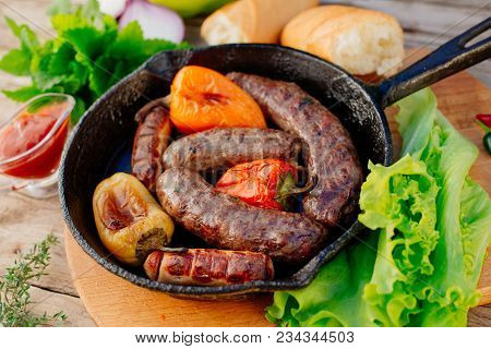 Oktoberfest. Assorted Different Grilled Sausages On A Wooden Table. Fried Sausages On A Cast-iron Fr