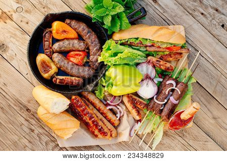 Oktoberfest. Assorted Different Grilled Sausages On A Wooden Table. Fried Sausages On A Cast-iron Fr
