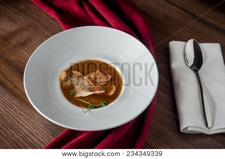 The Main Meat Dish On A Large Deep Plate. Restaurant. Gray Background, Dark Background, Parquet In T