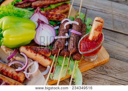 Oktoberfest. Assorted Different Grilled Sausages On A Wooden Table. Fried Sausages On A Cast-iron Fr