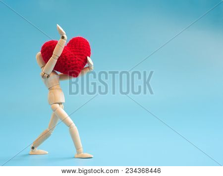 Wooden Puppet Walking And Hold Red Heart On The Sky Blue Screen Background. Wooden Puppet Handle The