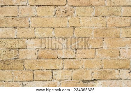 Textured Background Of A Stone Brick Of Yellow Antediluvian Masonry. Partially Destroyed Wall. Brick