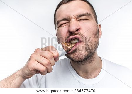 A Close Picture Of Guy Eating Sweet Bar Of Chocolate With Nouga. He Is Biting A Big Piece Of This Sw