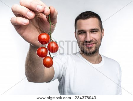 Attractive And Handsome Man Is Holding A Ramus Of Cherie Tomatoes. This Vegane Likes To Eat Every Fr