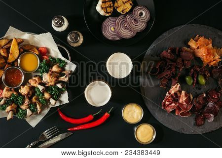 Top View Of Glasses Of Beer, Vegetables, Baked Potatoes With Roasted Chicken, Various Sauces And Cra