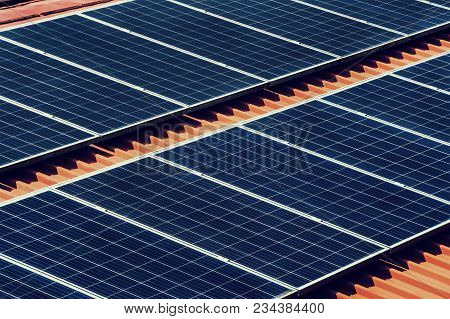 Large Photovoltaic Battery On Bower Roof, Alternative Energy. Black Solar Panel Closeup On Red Roof
