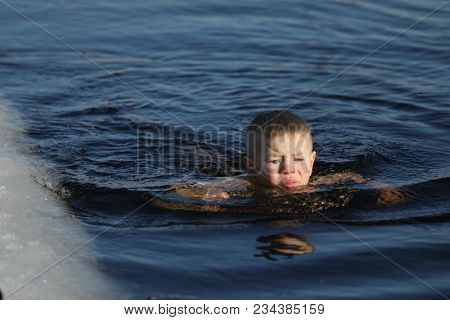 ST. PETERSBURG, RUSSIA - MARCH 4, 2018: Amateur teen winter swimmer at ice hole during Big Neva Cup. Winter swimmers from 12 countries aged from 12 to 78 take part in the competitions this year