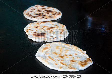Indian Chapatti On Fire, Pushkar, India Close Up. Fried Tortillas On A Hot Baking Sheet. Street Food