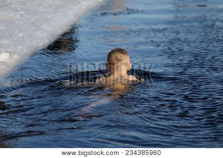 ST. PETERSBURG, RUSSIA - MARCH 4, 2018: Amateur teen winter swimmer at ice hole during Big Neva Cup. Winter swimmers from 12 countries aged from 12 to 78 take part in the competitions this year