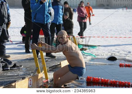 ST. PETERSBURG, RUSSIA - MARCH 4, 2018: Amateur winter swimmer at ice hole during Big Neva Cup. Winter swimmers from 12 countries aged from 12 to 78 take part in the competitions this year