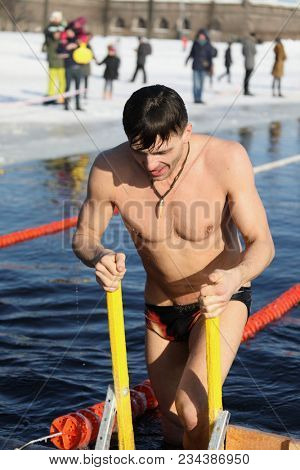 ST. PETERSBURG, RUSSIA - MARCH 4, 2018: Amateur winter swimmer at ice hole during Big Neva Cup. Winter swimmers from 12 countries aged from 12 to 78 take part in the competitions this year