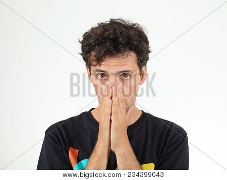 Calm Boy In T-shirt With Letters Holding His Hands At His Nose