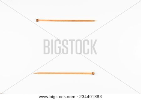 A Pair Of Wooden Knitting Needles On White Background. Top View