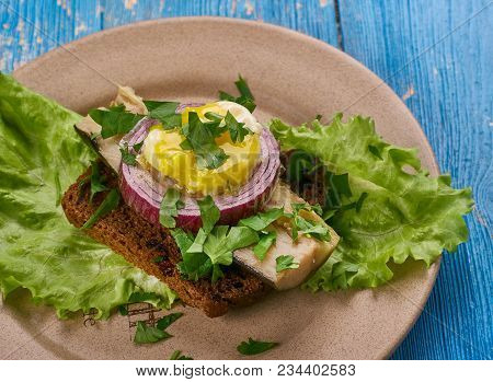Sol Over Gudhjem - Danish Dish, An Open Sandwich With Rugbrod, Smoked Herring, Chives And A Raw Egg
