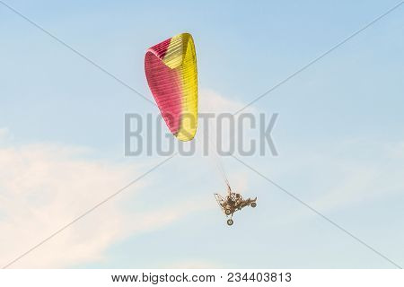 Take-off Of The Motor Paraglider Trike Skyward. Flight On Motor Glider In The Blue Sky.