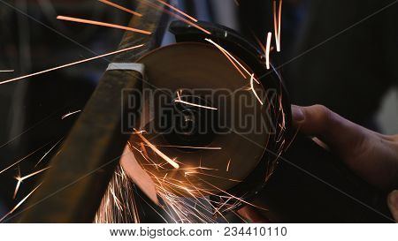 Worker Cuts A Metal Bar Of Angular Grinding Machine, Closeup