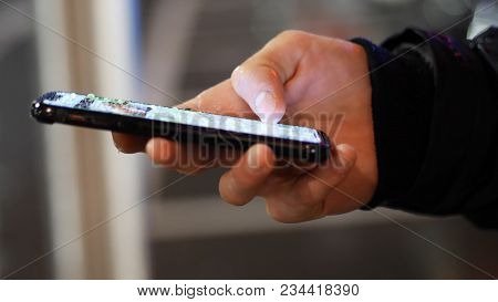 Male Hands Typing And Using Water-proof Smartphone Under Rain Dripping On The Display