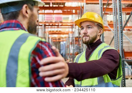 Portrait Of Warehouse Worker Patting His Colleague On The Back Meeting On Break And Chatting