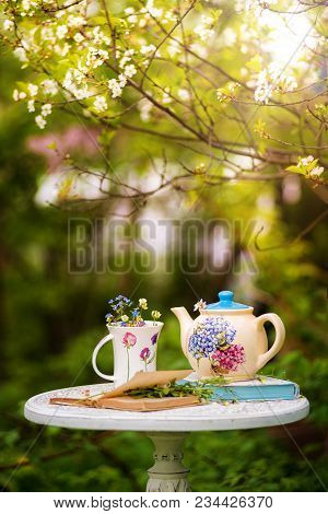 Kettle And A Cup Of Flowers In The Cherry Blossom Garden