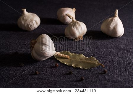 Bay Leaf, Onion And Garlic On The Textile Table Top. Dry Spices Mix