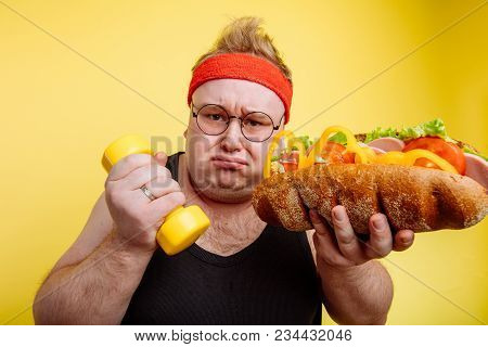Fat Sportsman Has Ruined The Diet With Yummy Humburger. Gluttony.