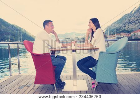 happy young couple having lanch at beautiful restaurant on the beach