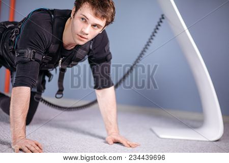 Man In Electrical Muscular Stimulation Suits Doing Plank Exercise. Ems. Workout.
