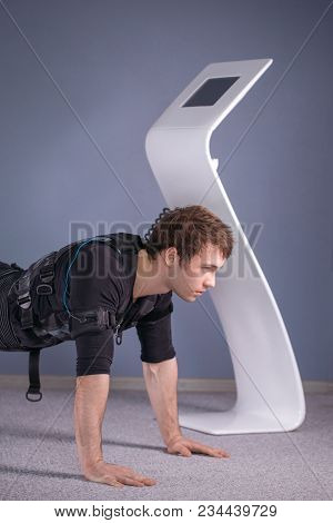 Man In Ems Suits Doing Plank Exercise. Workout.
