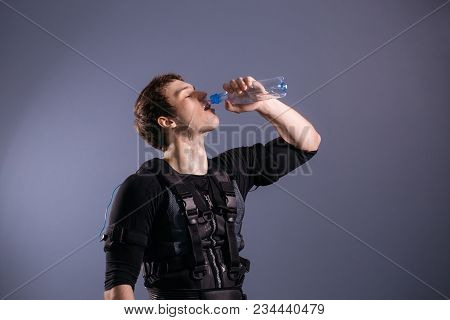 Fit Man Wearing Electro Stimulation Suit Drink Water After Training