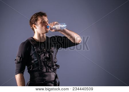 Fit Man Wearing Electro Stimulation Suit Drink Water After Training