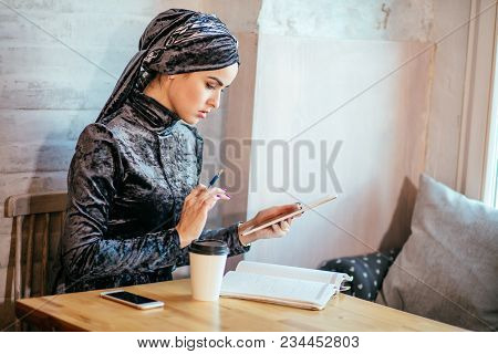 Young Asian Muslim Women Working With Tablet And Drink Coffee In Cafe
