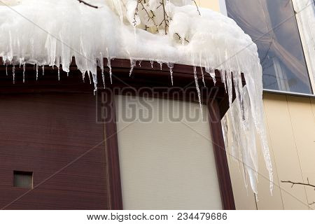 Building Covered With Big Icicles Icicles Hang From The Roof, Vertical Ice Stalactite Hanging From R
