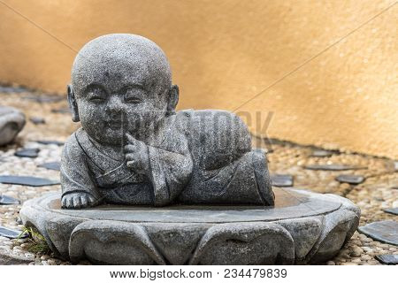 Hacienda Heights, Ca, Usa - March 23, 2018: Closeup Of Lying Down Boy Novice Monk Cement Statue In G