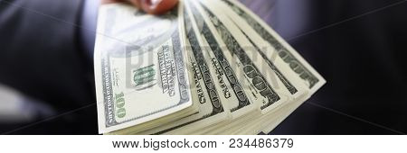 Man In Suit And Tie Hold In Arm Pack Of Hundred Dollar Bills Closeup. Stock Market Exchange Earn Pil