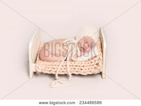 Little infant baby sleeping on tummy on wooden crib